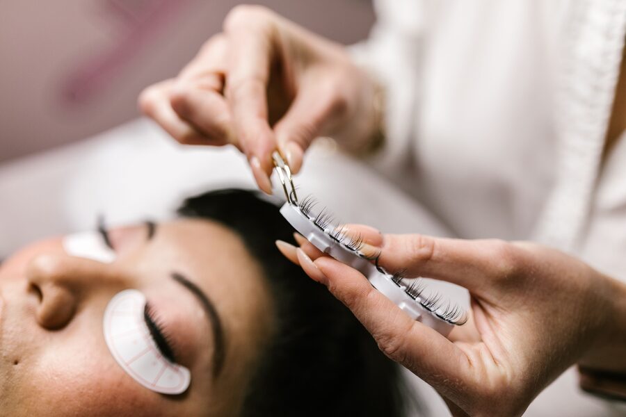 Stylistin entnimmt Wimpernfächer von der Palette